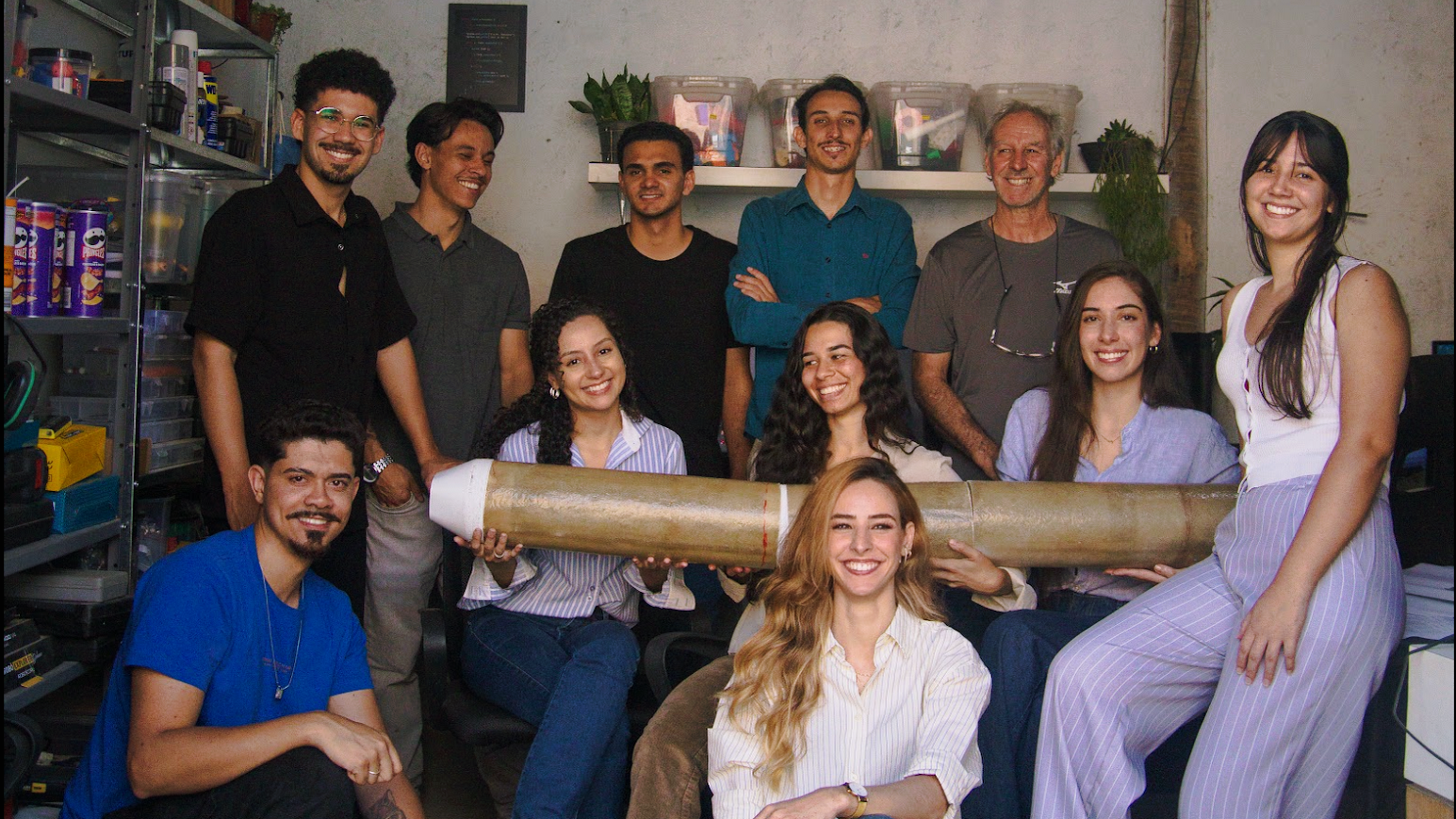 Equipe da Innovare Hub em torno de uma mesa com projetos técnicos, cercada por impressoras 3D no laboratório em Sarzedo.